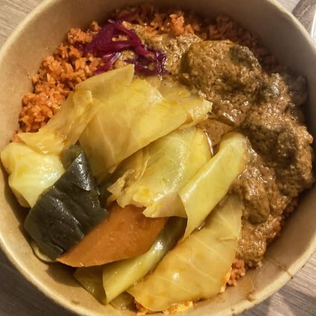 Bol kraft garni de riz rouge, de tchieb et de sauce mafé
