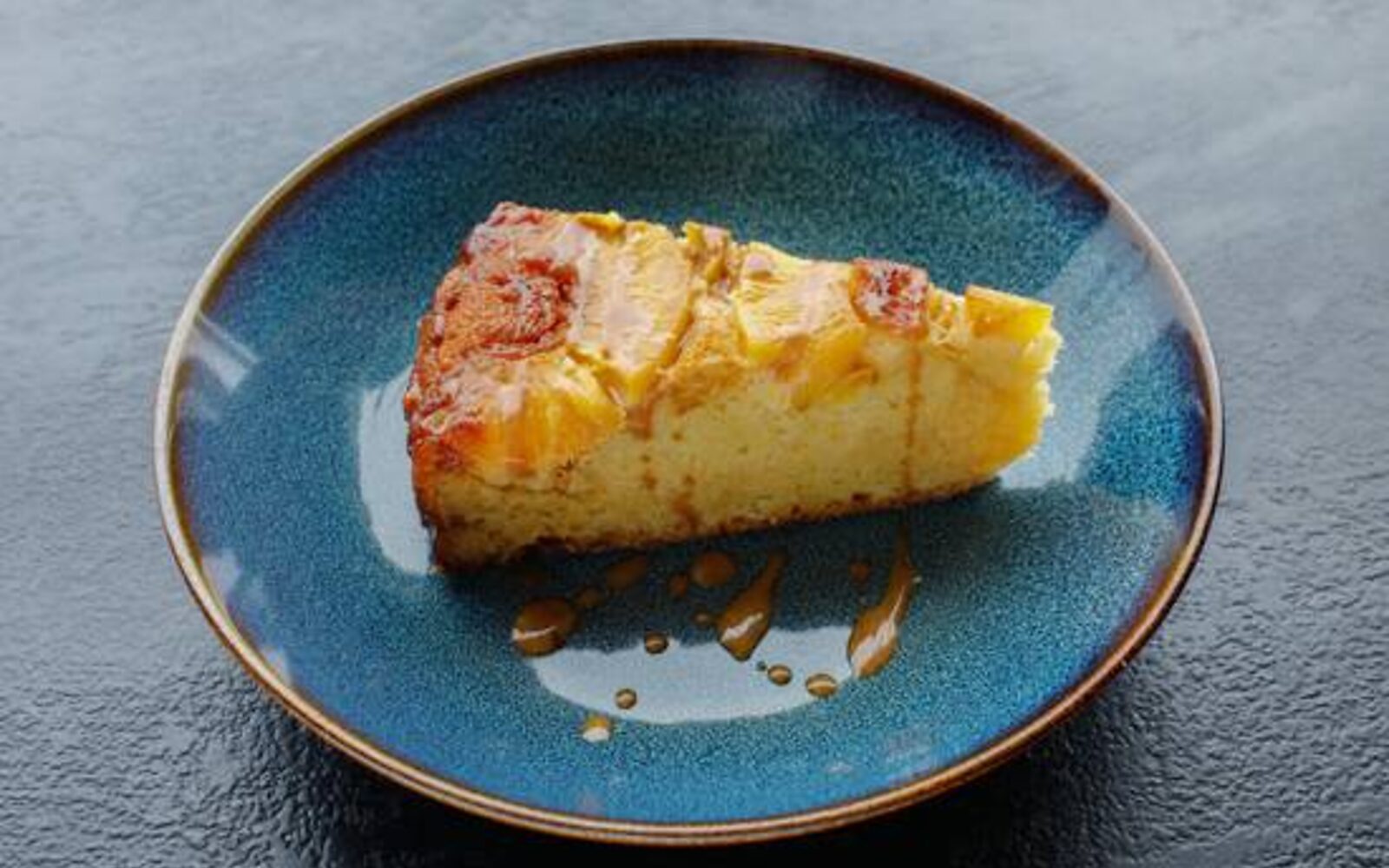 Une part de gâteau maison servie sur une assiette bleue