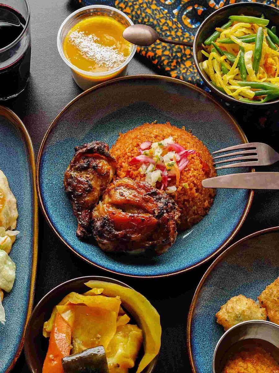 Une table dressée chez Bori Bori : bokit, riz rouge au poulet grillé, alloco, accras et bissap