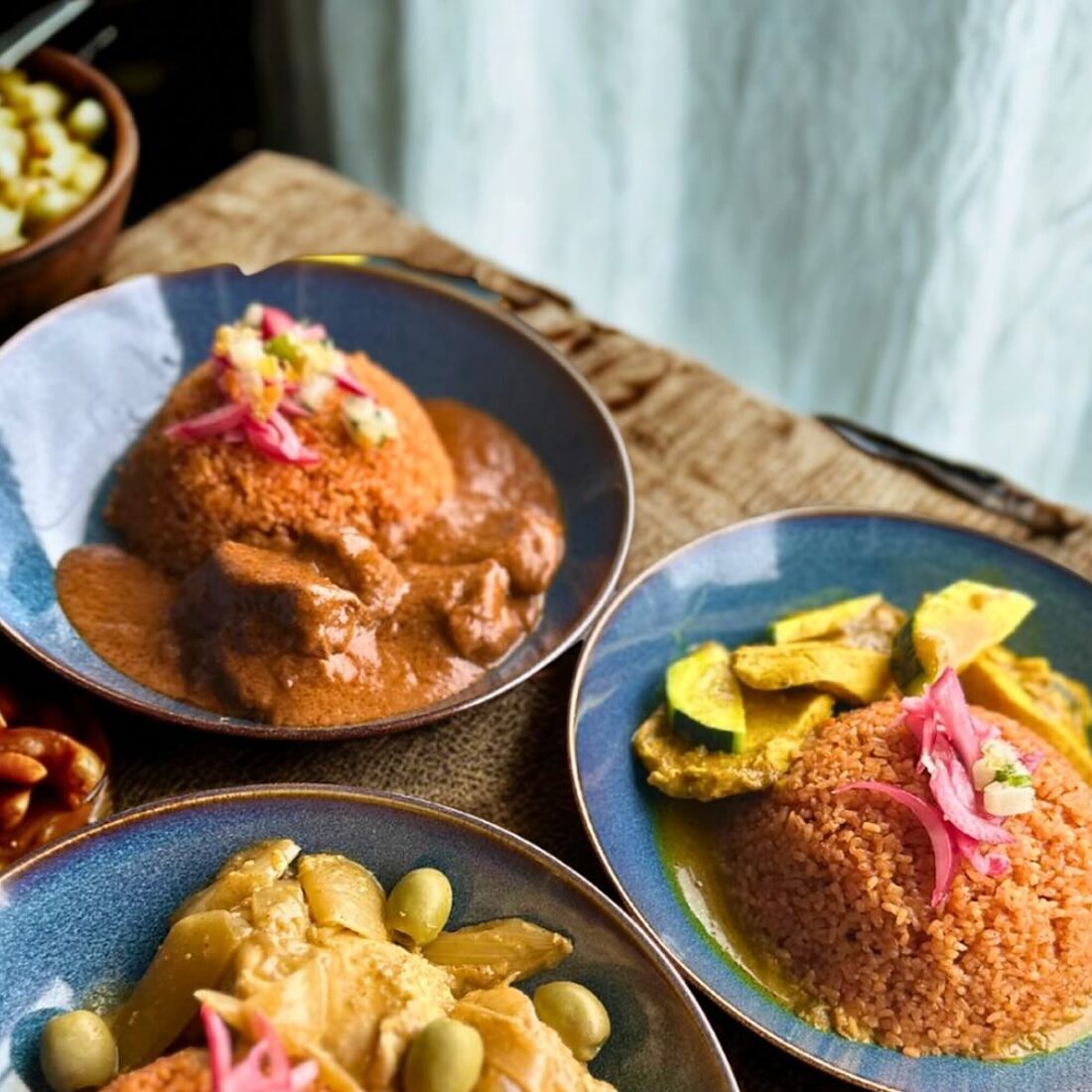 Assiettes de riz rouge, de mafé, de légumineuses et de légumes au curry