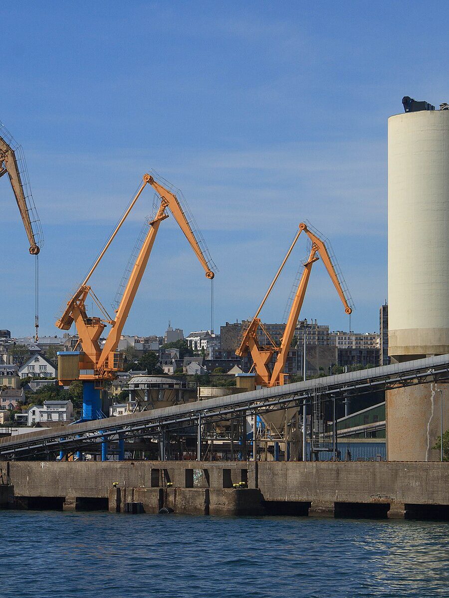 Les grues orange et les silos du port de commerce de Brest, vus depuis l'eau